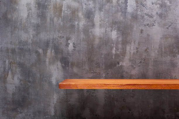 istock Wooden book shelf at abstract wall background or putty texture. Front view of tabletop 1309307743