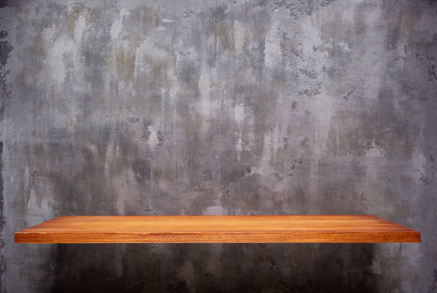 istock Wooden book shelf at abstract wall background or putty texture. Front view of tabletop 1309307766