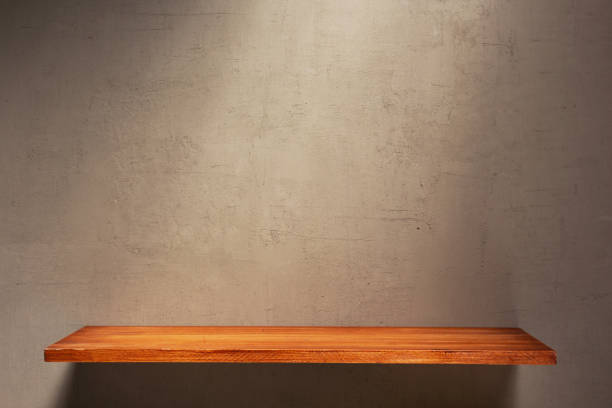 istock Wooden book shelf at abstract wall background or putty texture. Front view of tabletop 1309307783