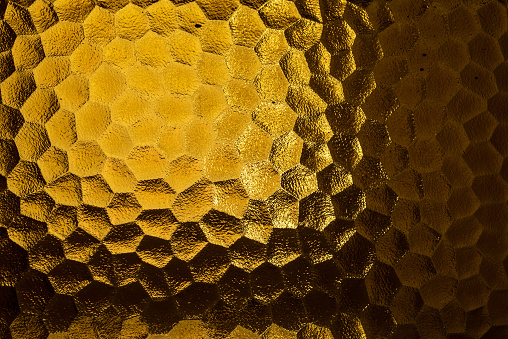 Abstract yellow coloured honeycomb shaped backlit glass background