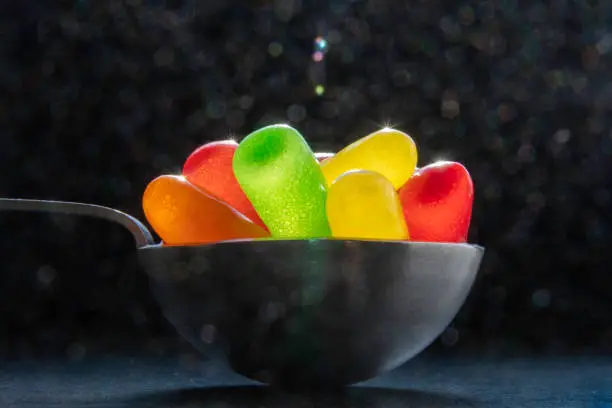 Fun, vibrantly colored movie jellybean-type candies with sunshine starbursts on a black background.