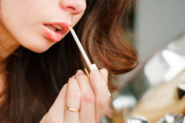 istock Young woman doing makeup, paints her lips with glitter 1309311657