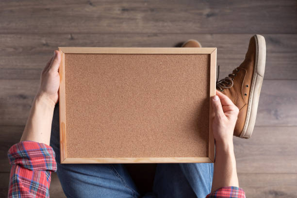 men's hand holding corkboard frame. male hand and cork board - cork tops imagens e fotografias de stock