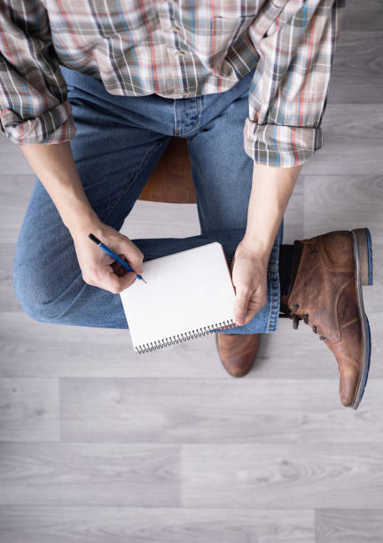 istock Men's hand holding pencil and notebook. Man student writing or drawing by pencil 1309311751