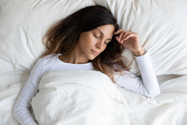 istock Top view peaceful beautiful young woman sleeping in bed 1309312513
