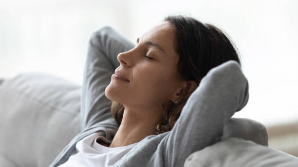 istock Close up peaceful woman with closed eyes resting on couch 1309312567