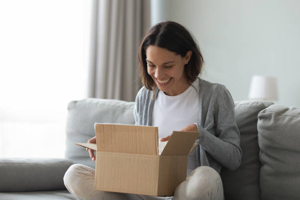 istock Close up overjoyed woman opening cardboard box with parcel 1309312572