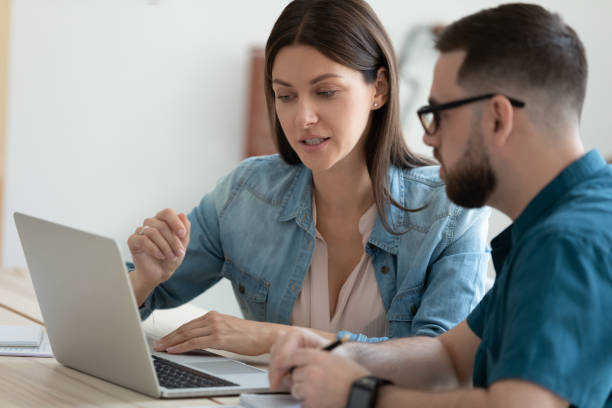 istock Diverse colleagues work on laptop together in office 1309314980