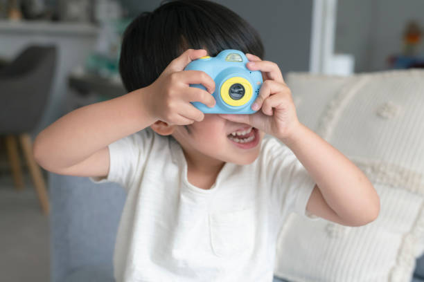 istock Cute toddler boy playing with toy camera 1309316055