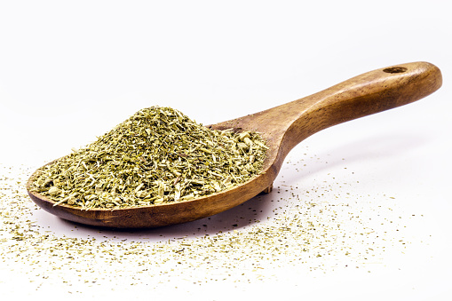 wooden spoon with yerba mate on isolated white background