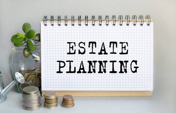 istock ESTATE PLANNING is written in a notebook that sits on the table along with a stack of coins, a glass jar with coins and a sprout, and a small toy watering can. Money saving concept. 1309317656