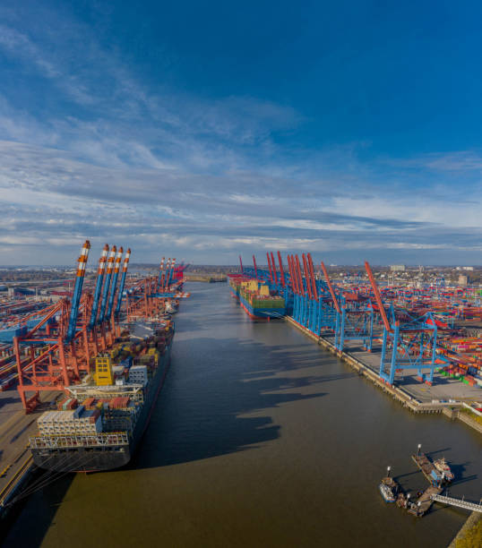 widok na terminal kontenerowy w hamburgu, załadunek i rozładunek różnych kontenerów transportowych i łodzi policyjnych na pierwszym planie. port morski nad łabą w hamburgu. - elbe valley zdjęcia i obrazy z banku zdjęć