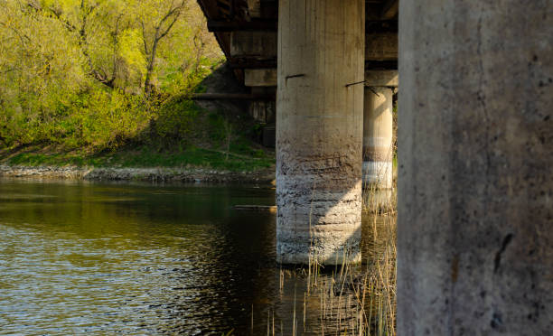 istock Destruction of the reinforced concrete column of the bridge. Bridge construction problems. Erosion of concrete from water. Destruction of concrete 1309320011