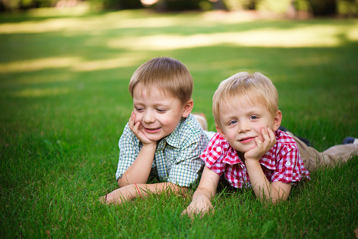Two young boys walk and relax in the park