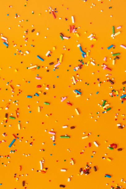 istock Colorful edible sugar sprinkles background - seamless pattern on yellow background. 1309326649