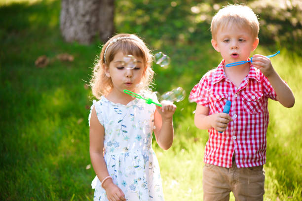 istock Five years old caucasian child girl and boy blowing soap bubbles 1309326830