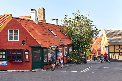 Gudhjem, Bornholm island, Denmark - June 29, 2019. Tourists watching shop display in the town of Gudhjem