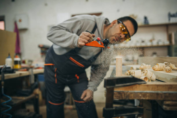 istock Carpenter scraping wood with planer 1309332329