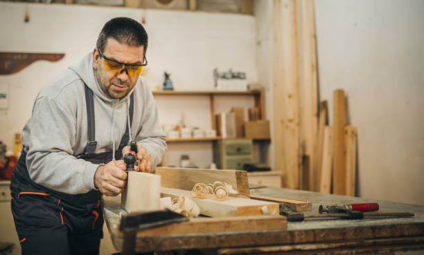 istock Carpenter scraping wood with planer 1309332362