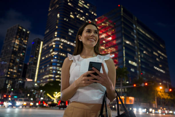 istock Business woman at a financial district using app on her cell phone 1309332946