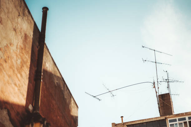 Old style Television  Antenna and satellite on the roof with the house