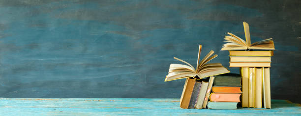 istock stack of books and two open books. Reading,literature,education,library,home office concept, good copy space 1309338431