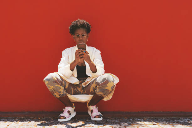 istock Black girl is phoning near red wall 1309338502