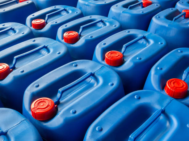 embalagem azul com tampas vermelhas para produtos químicos de embalagem é empilhada e organizada dentro do armazém baldes plásticos para manter a qualidade dos produtos químicos - chemical bottle cap chores - fotografias e filmes do acervo