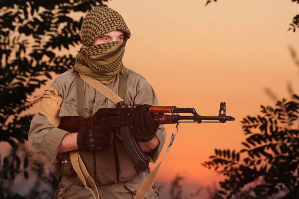 istock Guerrilla warfare. Insurgent with AK 47 rifle in forest. 1309339971