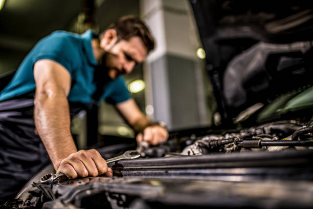 istock Worried mechanic examining engine problems in auto repair shop. 1309348991