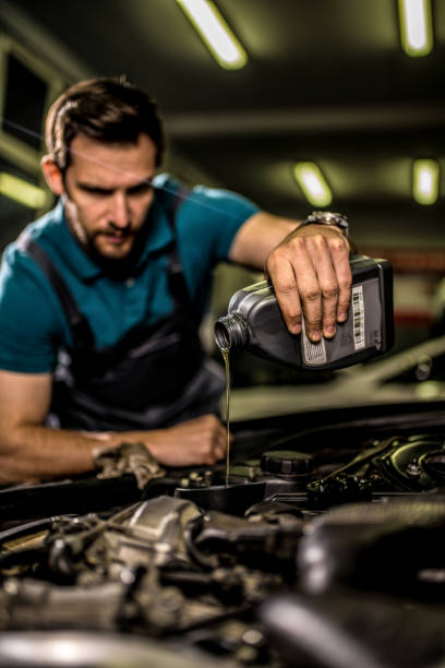 istock Mechanic changing oil on the vehicle at car workshop. 1309349923