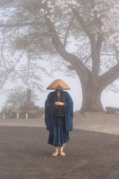 Japanese Zen Buddhist monk standing in front of the cherry blossoms Japanese Zen Buddhist monk standing in front of the cherry blossoms rinzai zen buddhism stock pictures, royalty-free photos & images