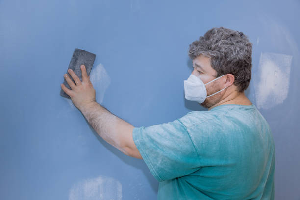 istock Worker sanding the drywall mud using sand trowel during renovation the house 1309358803
