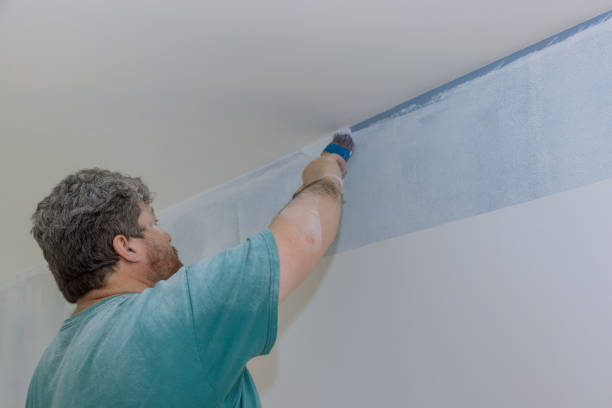 istock Home renovation applying paint on wall using brush painter working indoors 1309358813