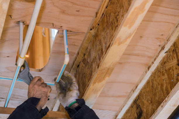 istock Plumbing building contractor cut a polypropylene pipe with scissors the hands of a worker in white gloves 1309358840