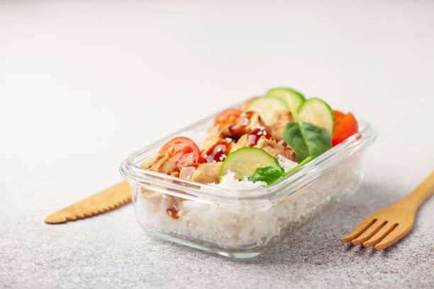 filete de pollo con arroz y verduras en un recipiente de vidrio sobre la mesa. concepto de comida escolar, deportiva o empresarial - salad glass chicken garnish fotografías e imágenes de stock