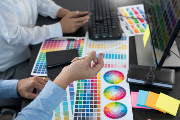 istock Graphic designer or creative working together coloring using graphics tablet and a stylus at desk with colleague 1309363626