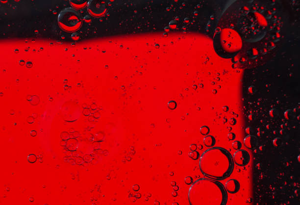 istock Oil bubbles on the water surface in motion, on a red background, macro, splash screen, template, copy space 1309364342