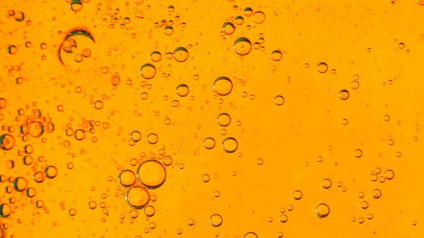 istock Oil bubbles on the water surface in motion, on a yellow-red background, macro, splash screen, template, copy space 1309364361