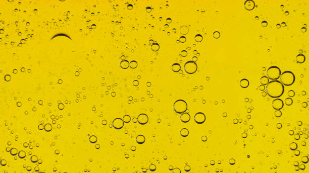 istock Oil bubbles on the water surface in motion, on a yellow background, macro, splash screen, template, copy space 1309364372