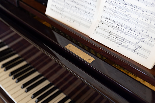 Sheet music on the classical grand piano keyboard (selective focus)