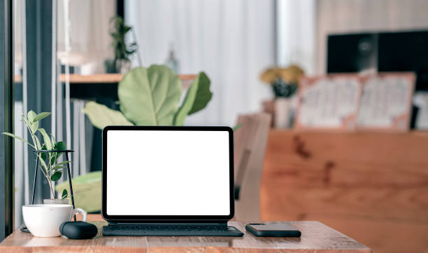 istock Mockup comfortable wokspace with blank screen tablet computer on wooden table in cafe room. 1309368642