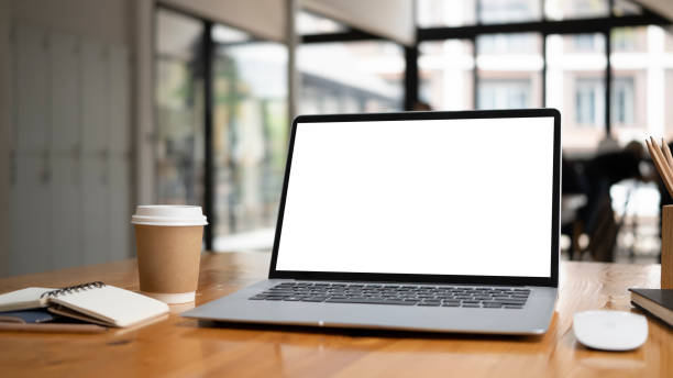 istock Close up view of computer laptop with blank screen on wooden table at modern office. 1309370241