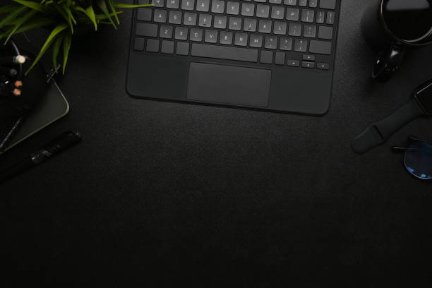 istock Top view of modern dark office with wireless keyboard, smart watch coffee cup on on black leather. 1309370834