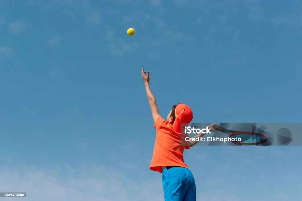 Foto de Tenista Infantil Em Roupas Esportivas Laranjas Com Raquete