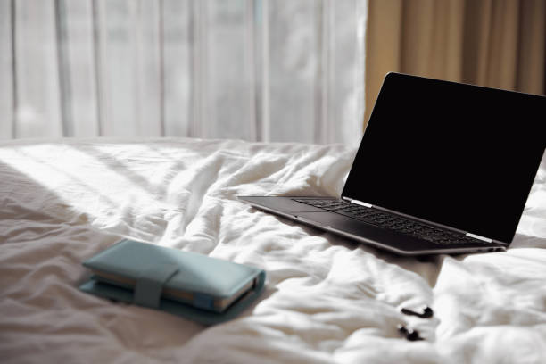 istock Laptop, planner and headphones on bed in sunlight 1309374359