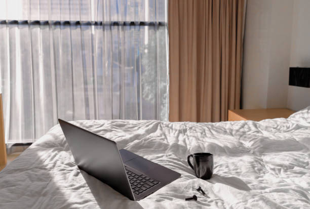 istock Laptop, planner and headphones on bed in sunlight 1309374508