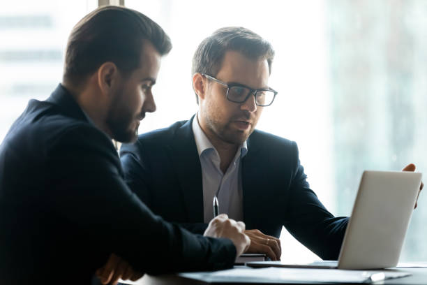istock Caucasian businessmen work on laptop brainstorming in office 1309380749
