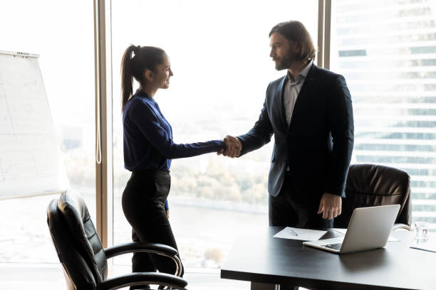 istock Diverse business partners shake hands at meeting 1309380751