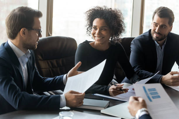 istock Smiling multiracial colleagues discuss paperwork at meeting 1309380760
